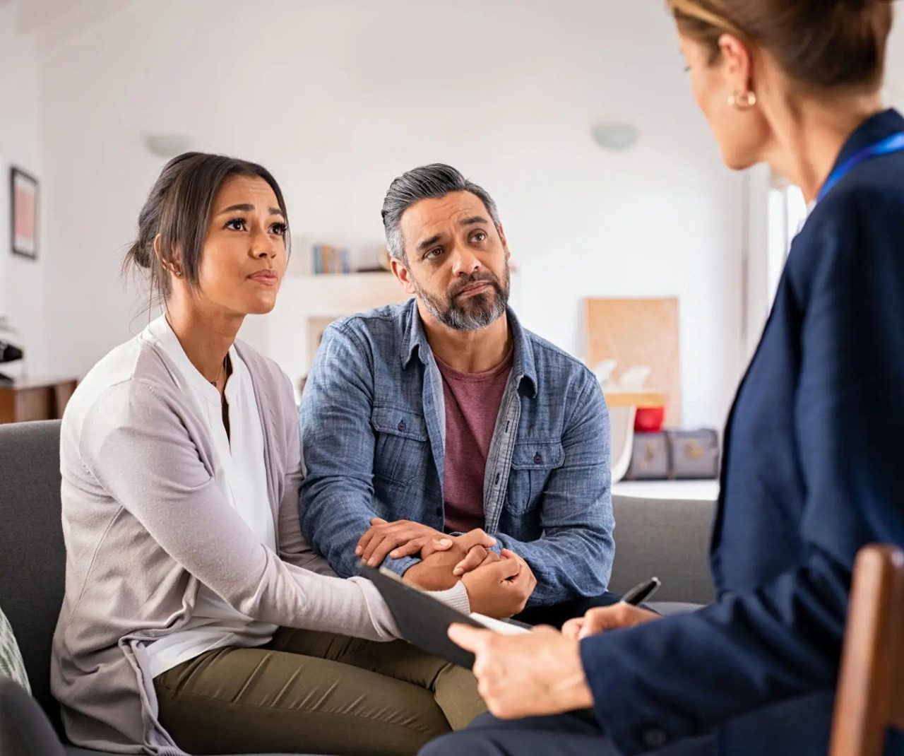 Couple holding hands during a counseling session.