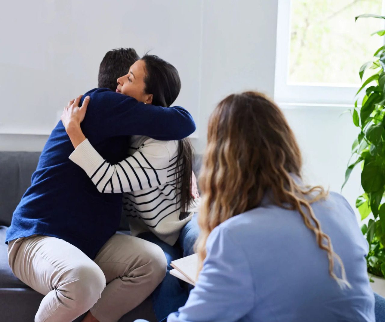 People hugging during a therapy session.